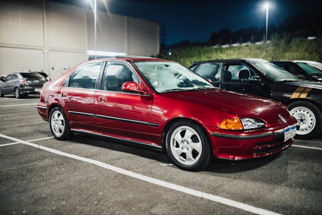 red honda parked outside of building